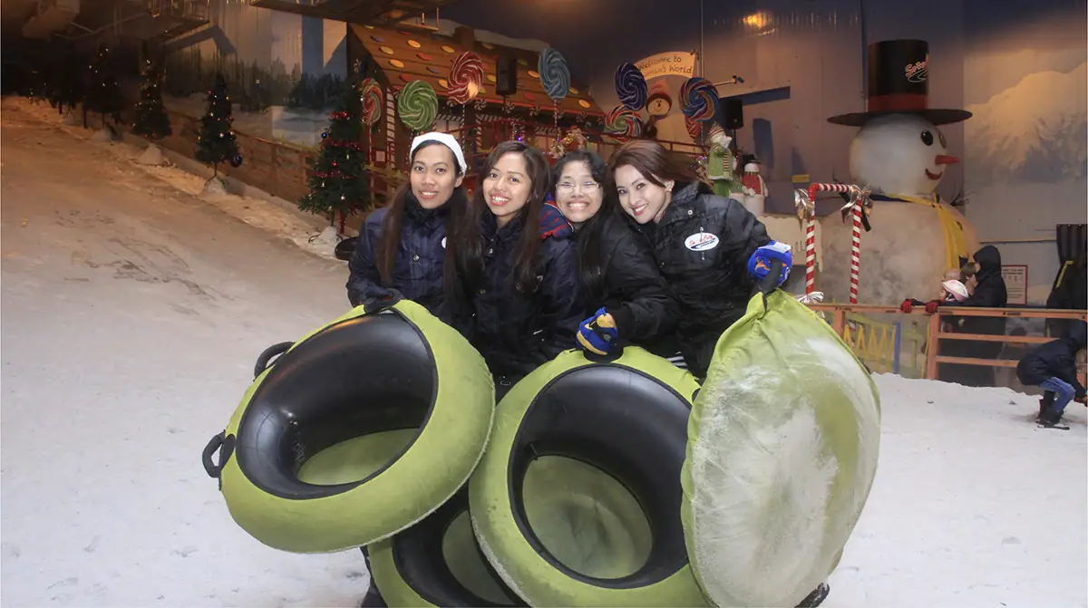Visitors enjoying snow tubing at an indoor snow park