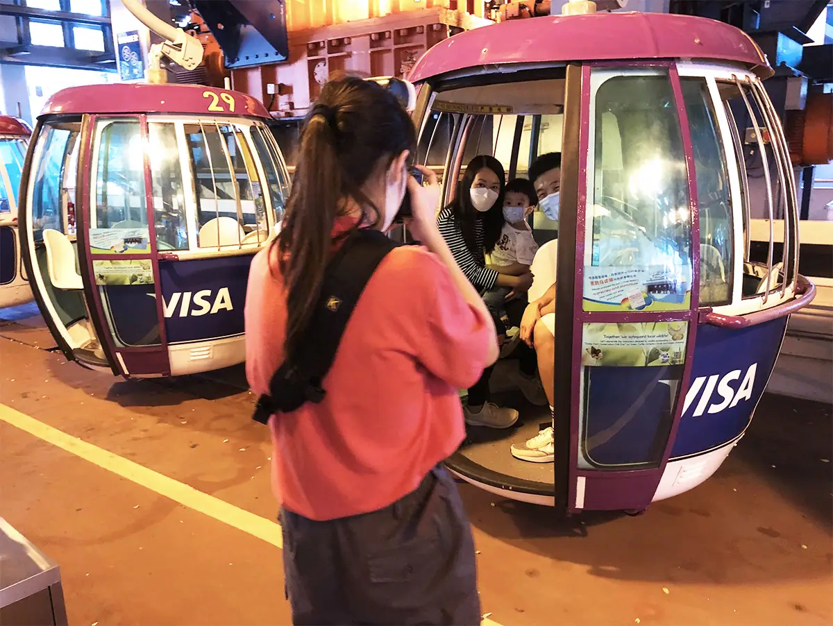 A photographer capturing guests inside a cable car attraction